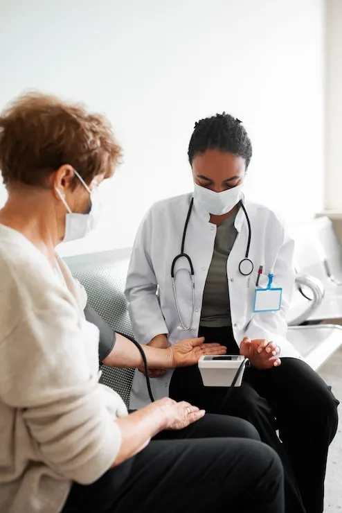 Physician checking a patient's blood pressure during a visit