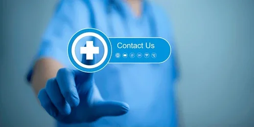 A clinician in scrubs reaching out to touch a Contact Us button on a screen