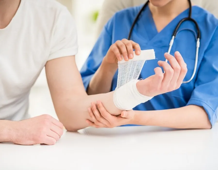 A nurse applying a fresh dressing to a patient’s forearm
